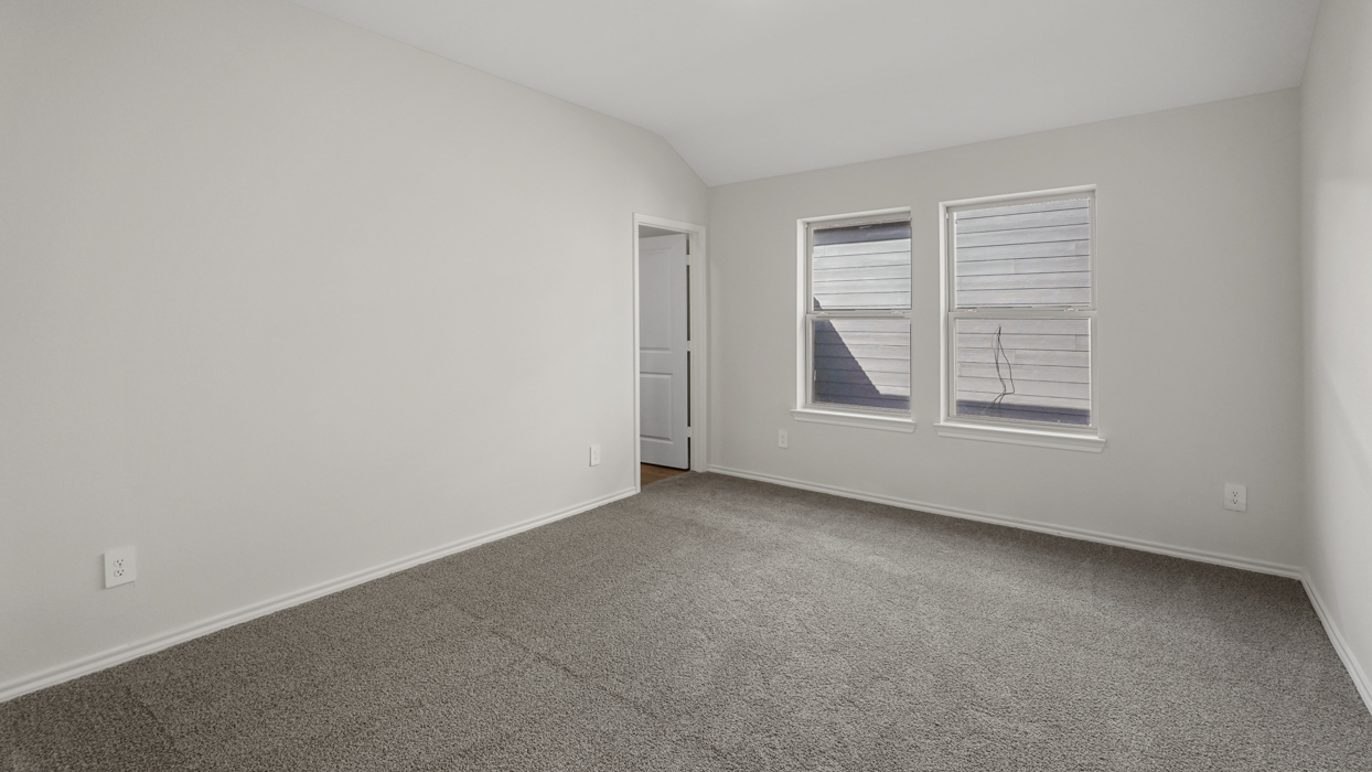 an open bedroom with white walls and gray carpet