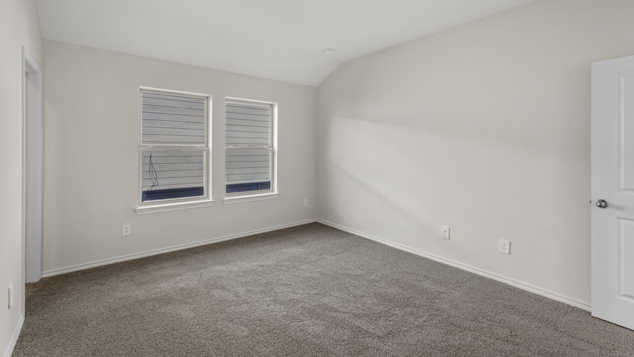 an open bedroom with white walls and gray carpet