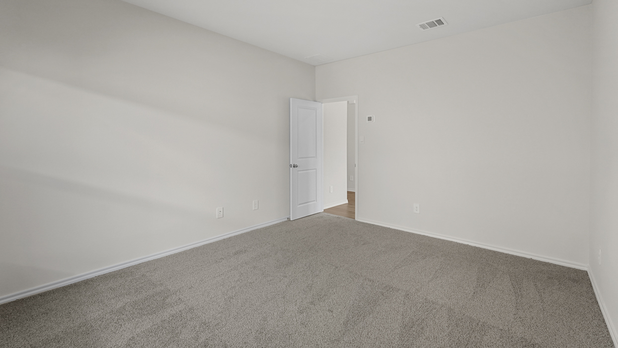 an open bedroom with white walls and gray carpet