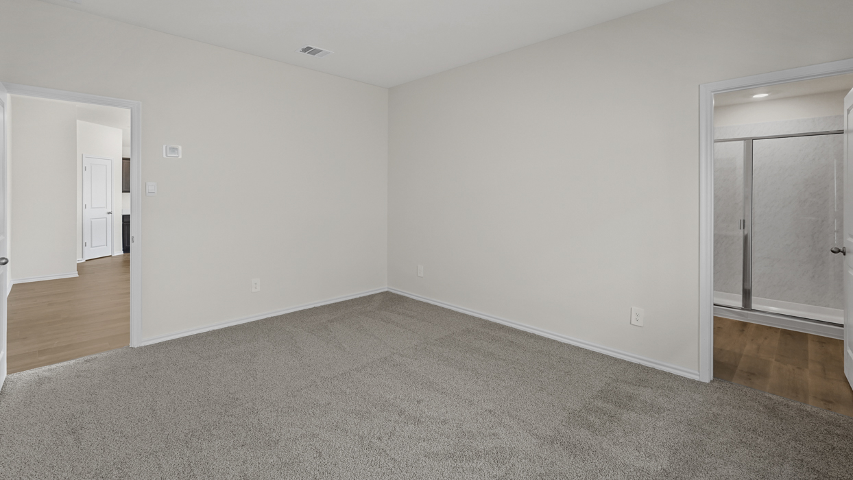 an open bedroom with white walls and gray carpet