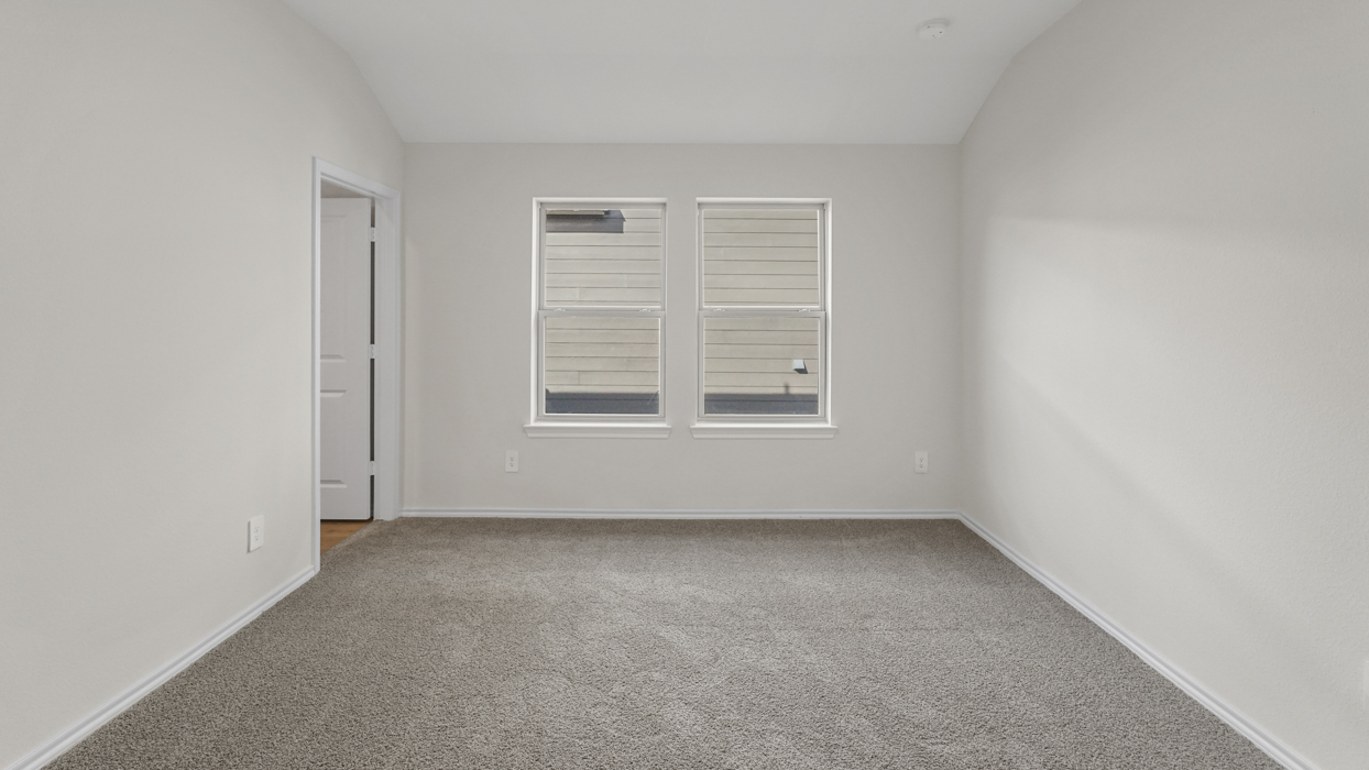 an open bedroom with white walls and gray carpet