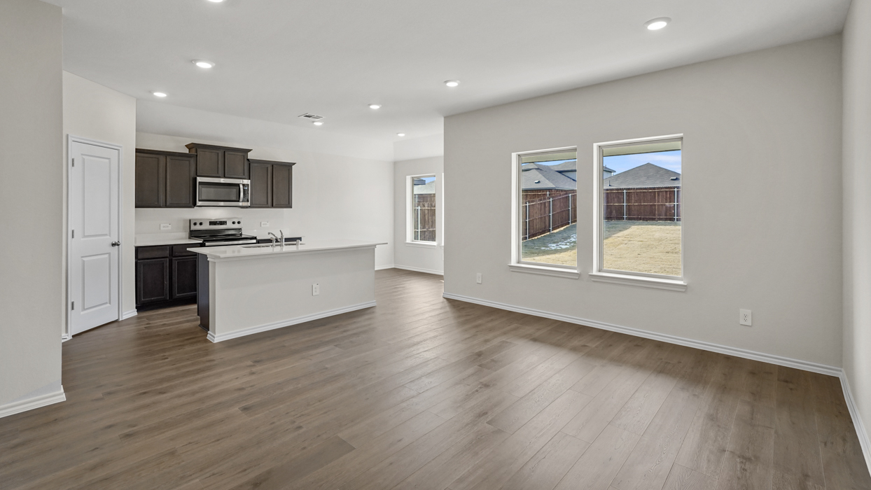 an open living area with white walls and wood floors