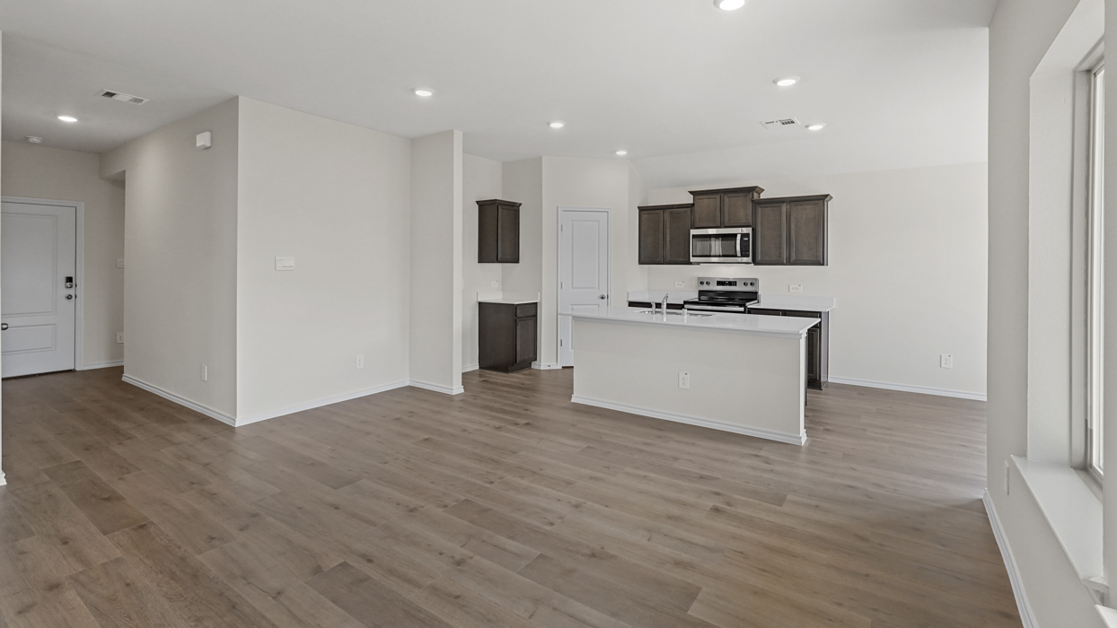 an open living area with white walls and wood floors