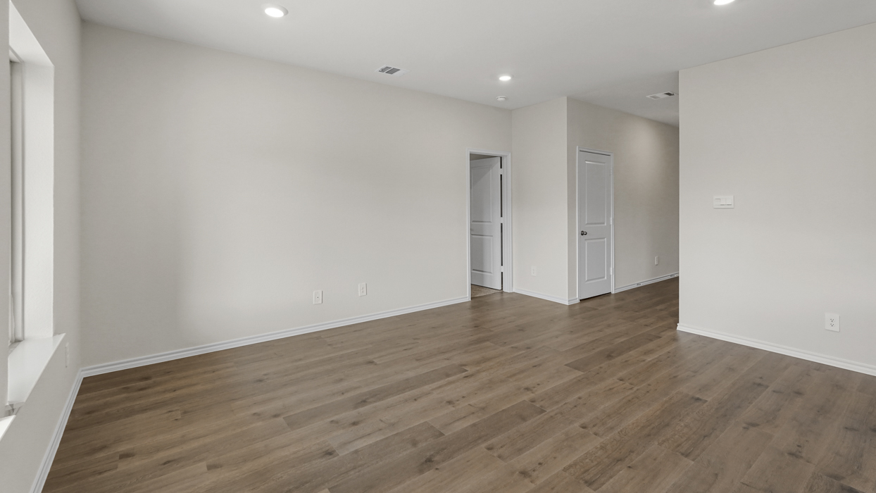an open living area with white walls and wood floors
