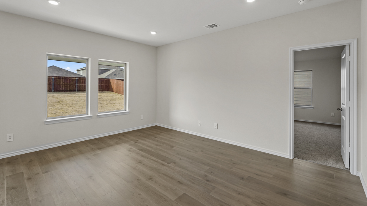 an open living area with white walls and wood floors