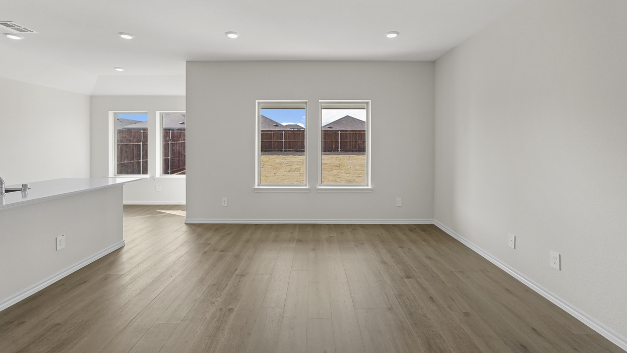 an open living area with white walls and wood floors