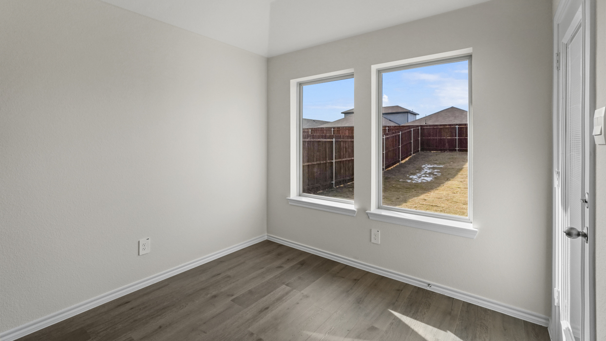 an open living area with white walls and wood floors