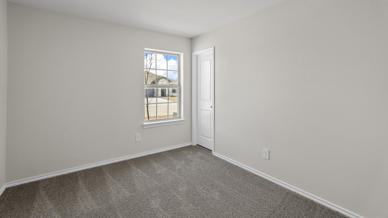 an empty bedroom with windows gray carpet and white walls
