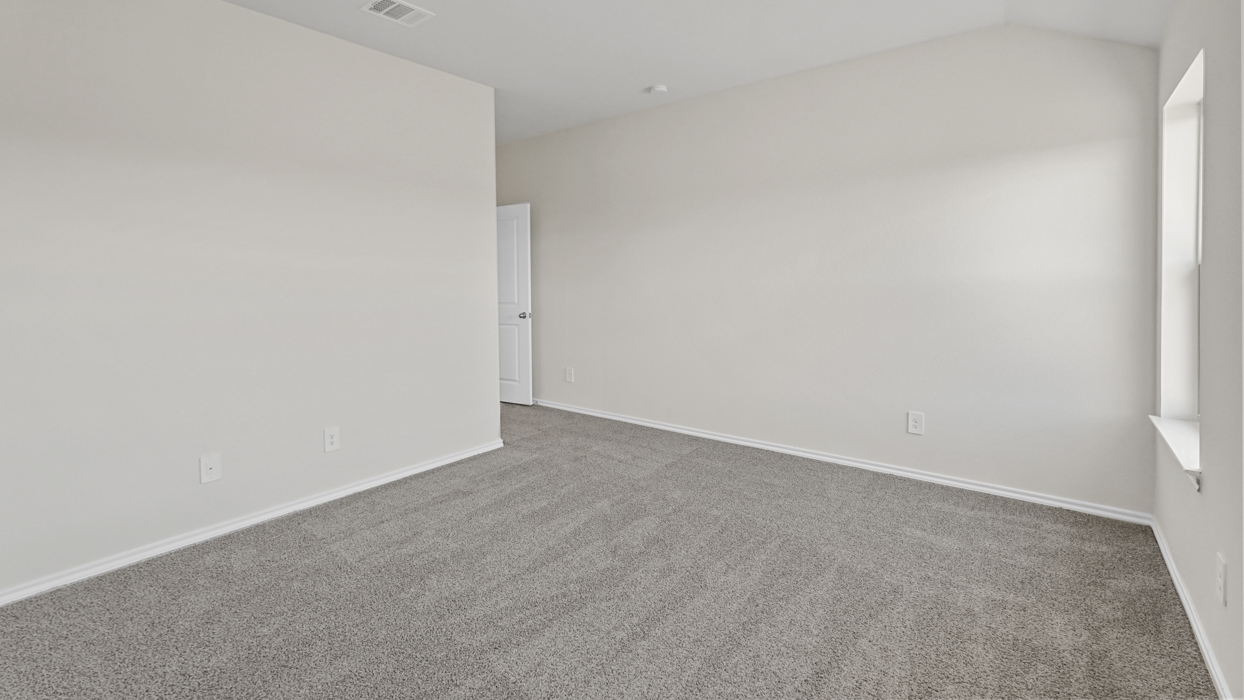 an empty bedroom with windows gray carpet and white walls