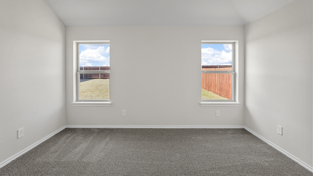 an empty bedroom with windows gray carpet and white walls