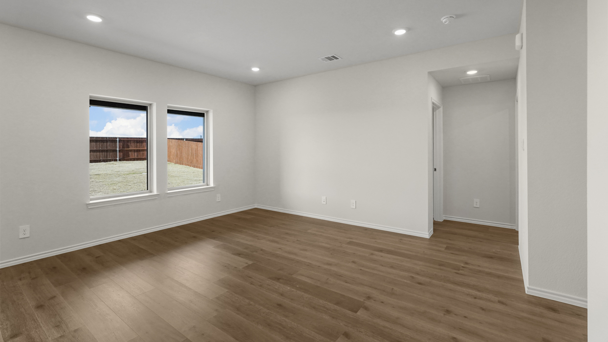 an open living area with windows and white walls and wood floors