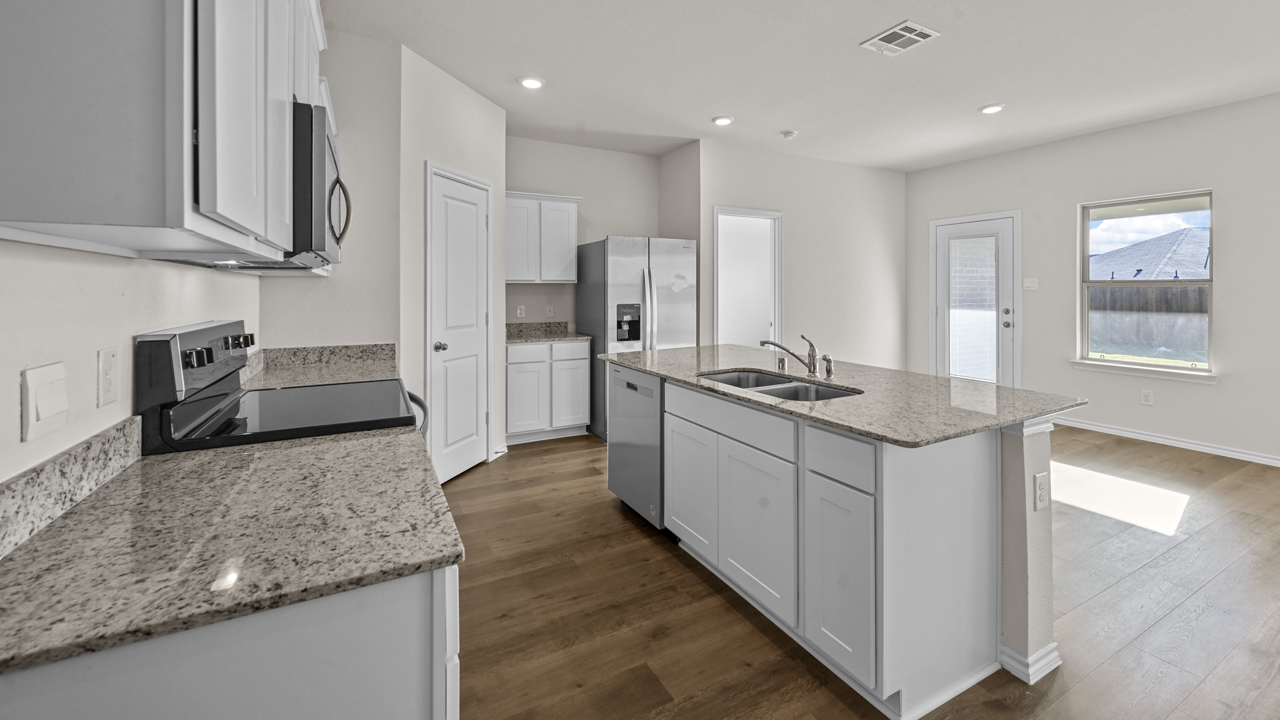 a kitchen with white cabinets and an island in the middle white walls and wood floors