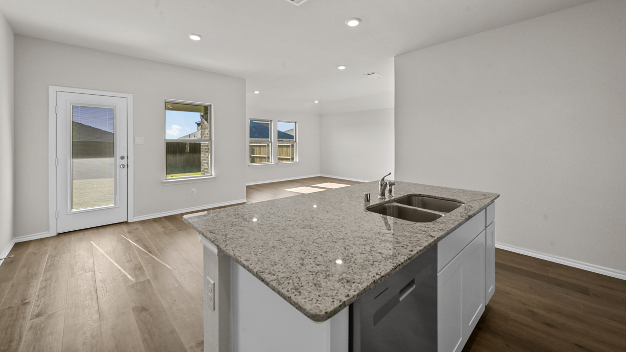 a kitchen with white cabinets and an island in the middle white walls and wood floors