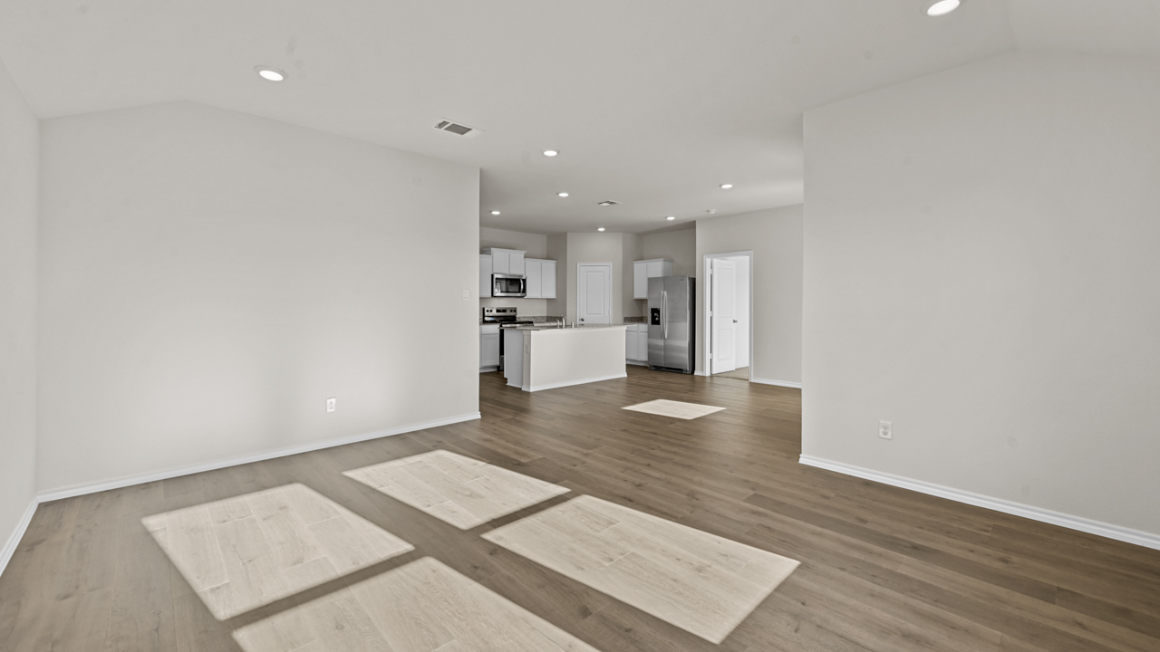 an open living area with wood floors white walls and windows