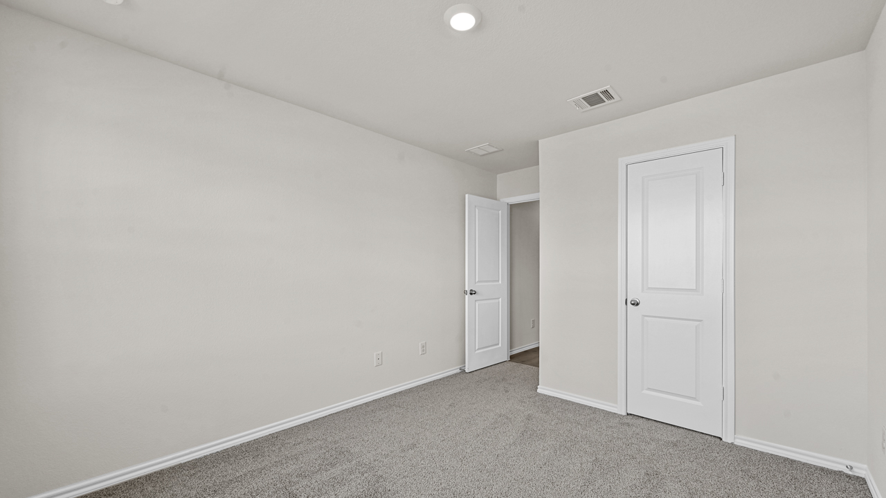 an empty bedroom with gray floors and white walls