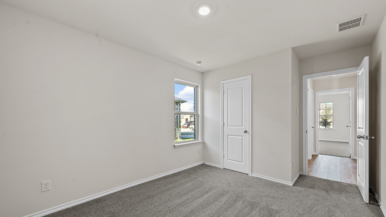 an empty bedroom with gray floors and white walls