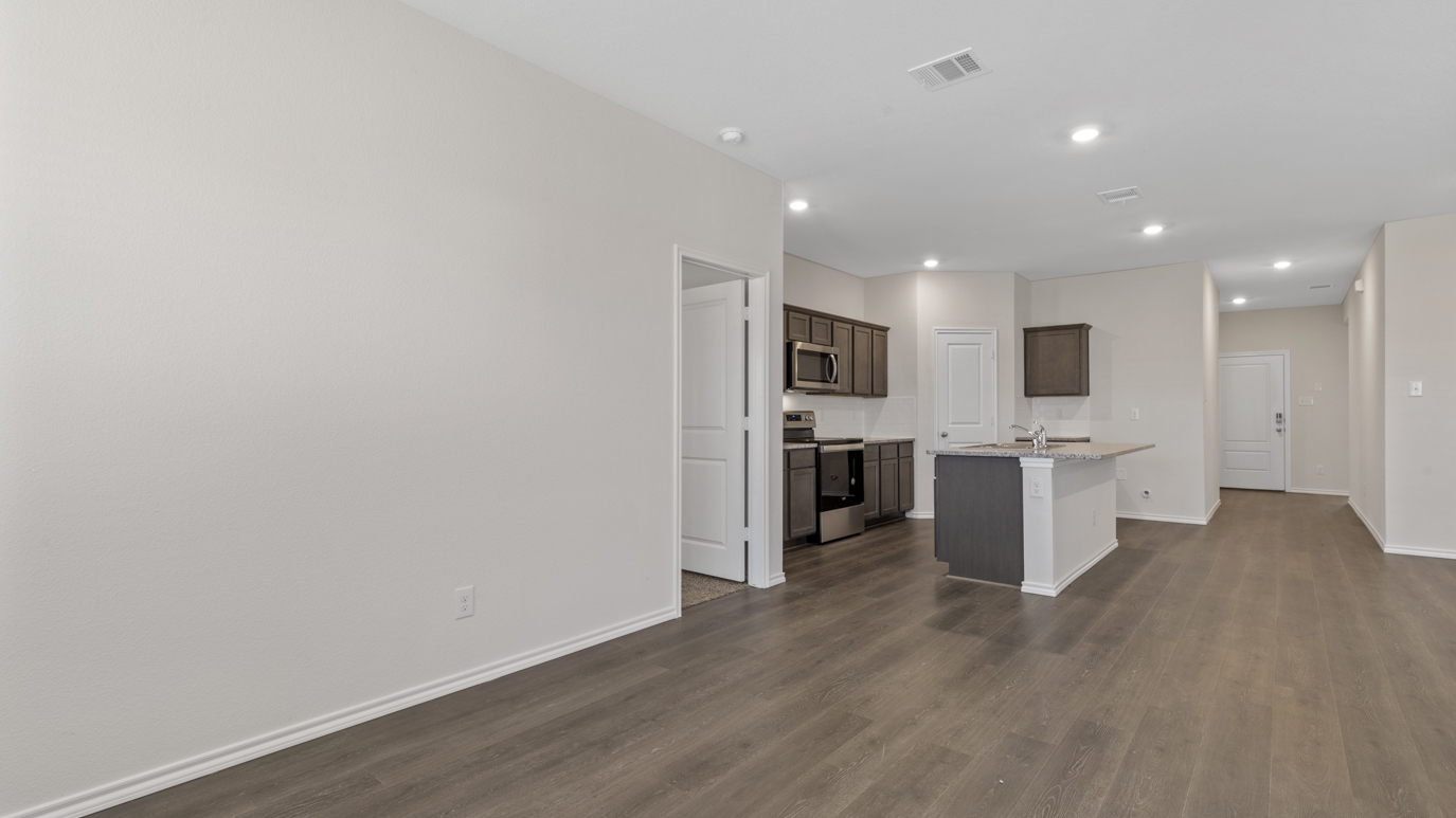 an open living area with white walls and wood floors