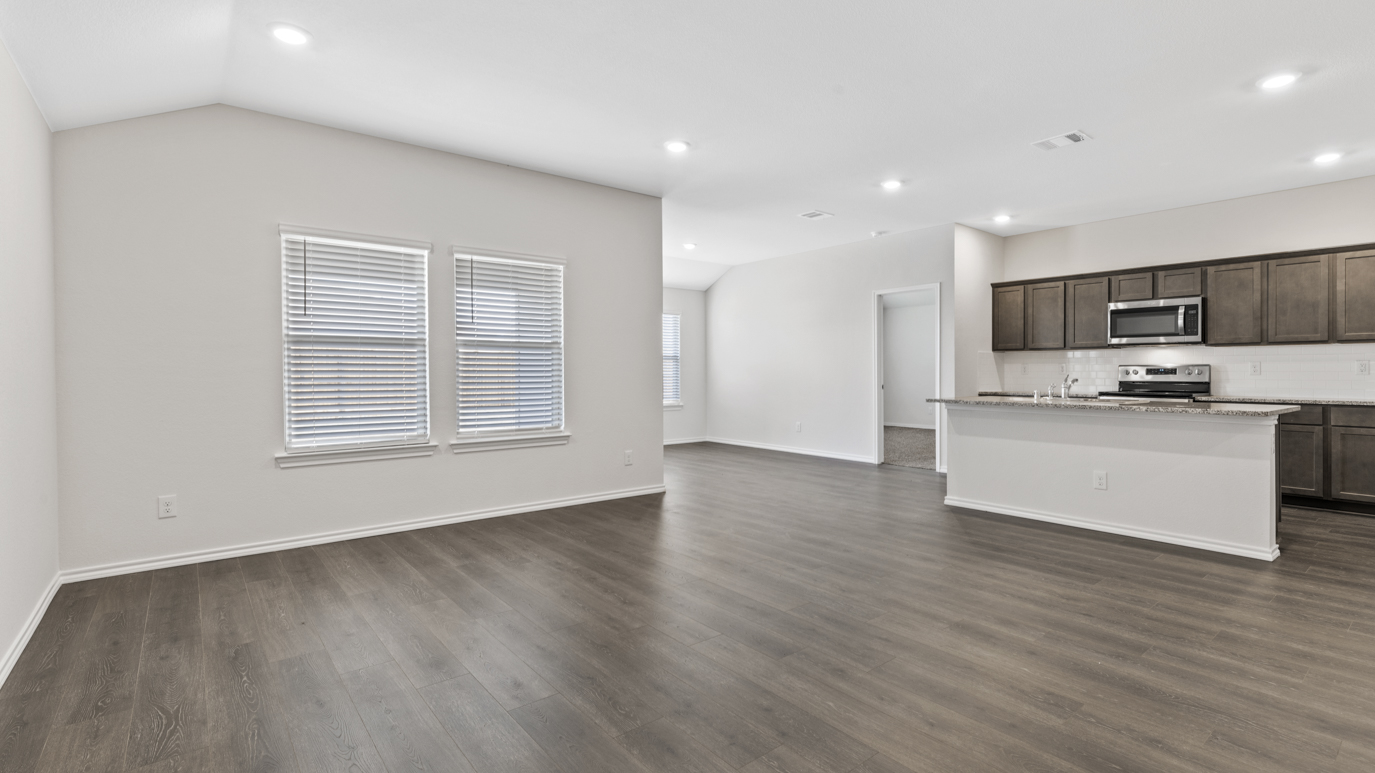 an open living area with white walls and wood floors
