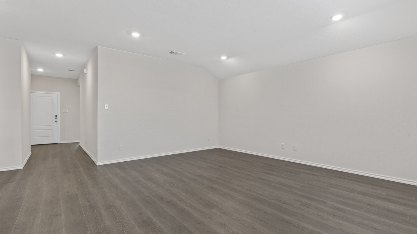 an open living area with white walls and wood floors