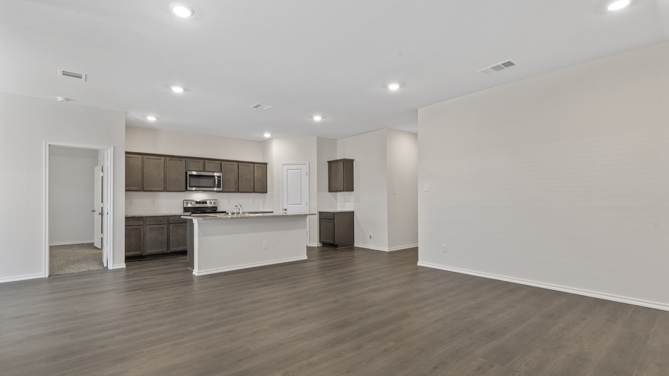 an open living area with white walls and wood floors
