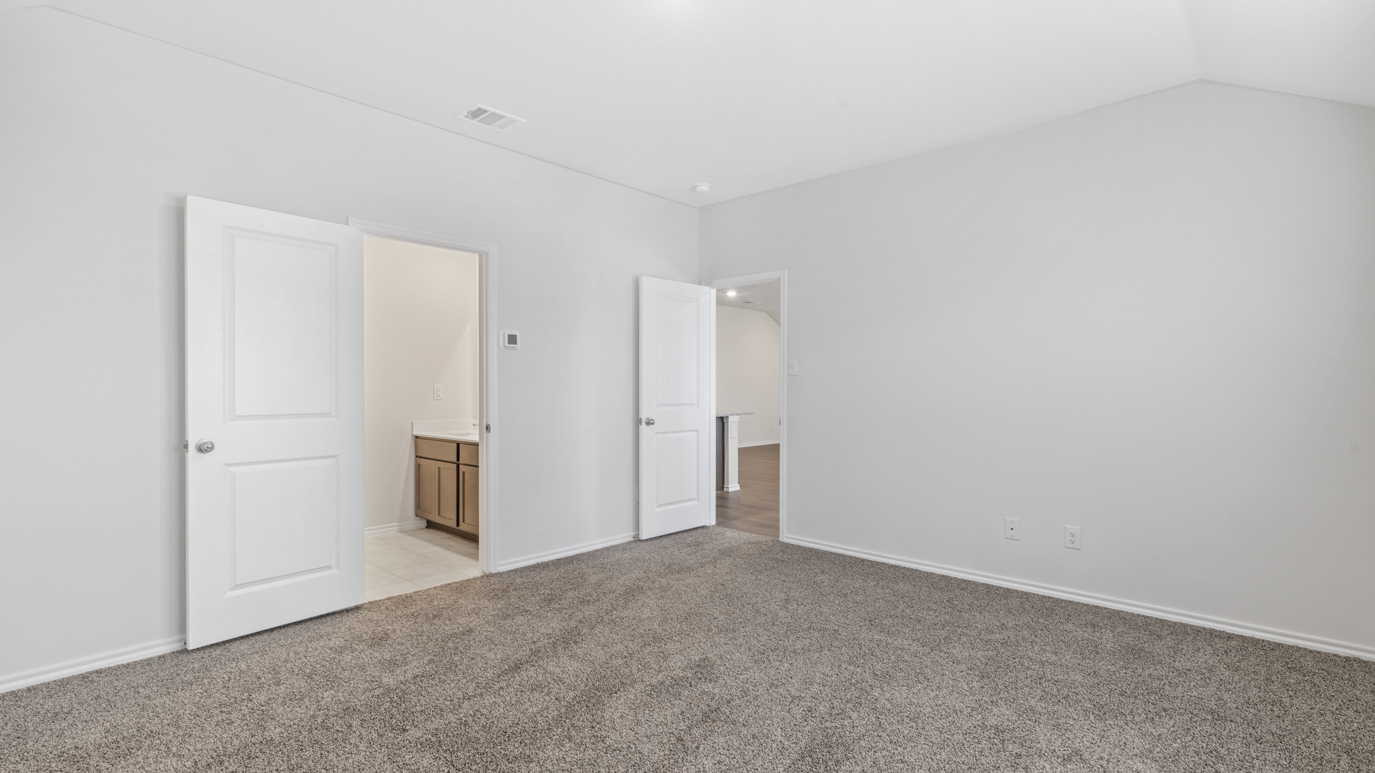 an empty bedroom with gray carpet windows and white walls