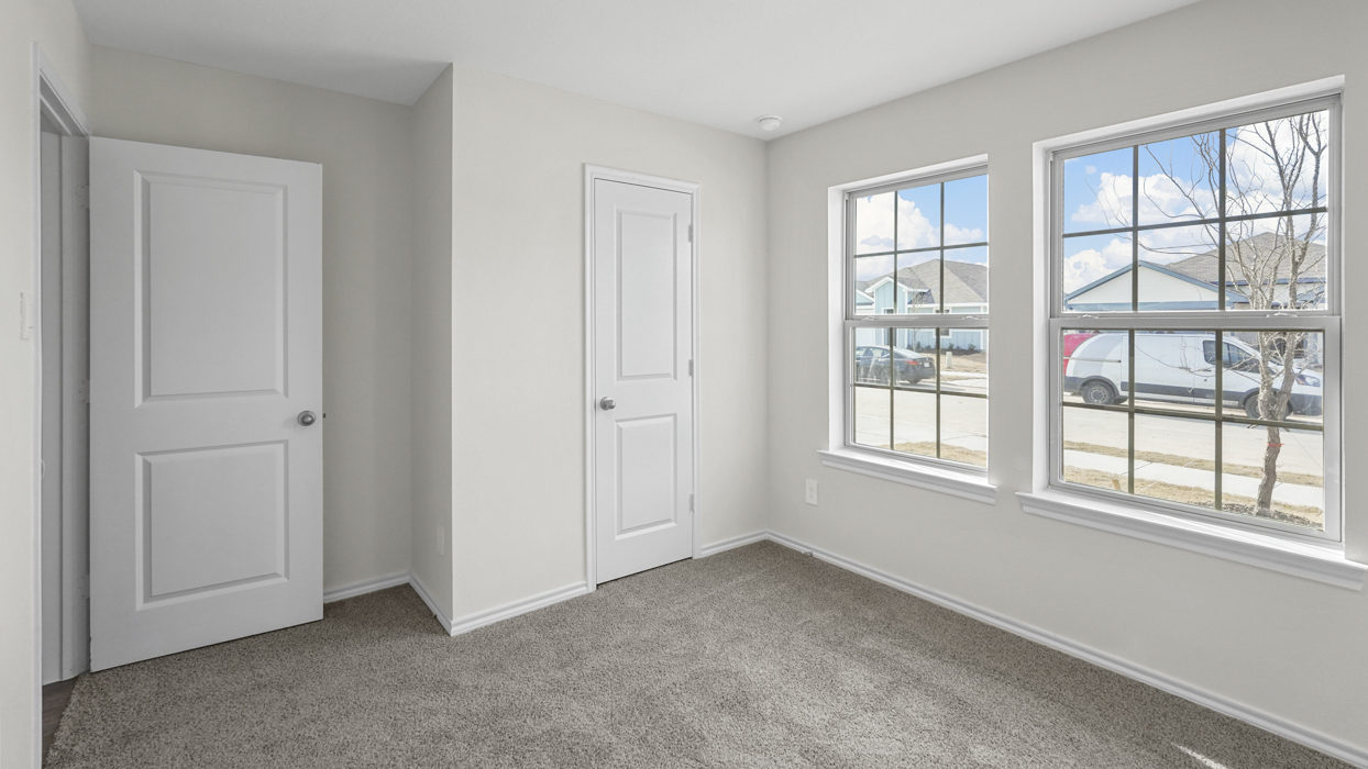 an empty bedroom with gray carpet and white walls