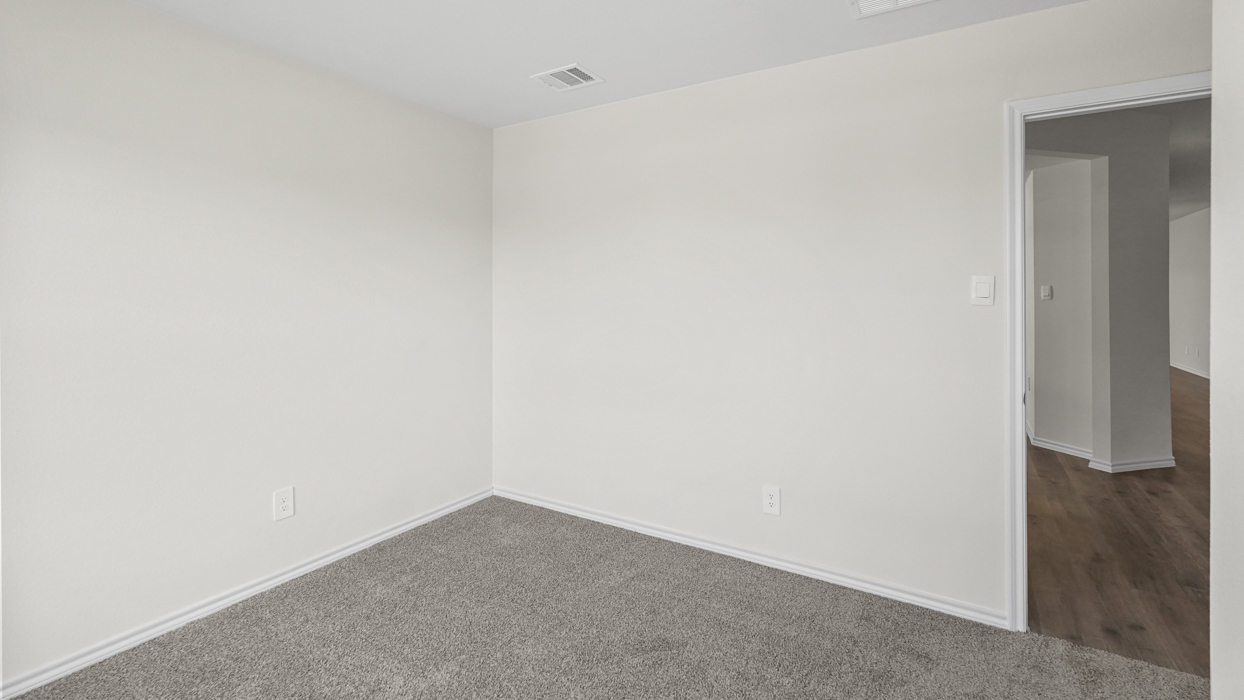 an empty bedroom with gray carpet and white walls