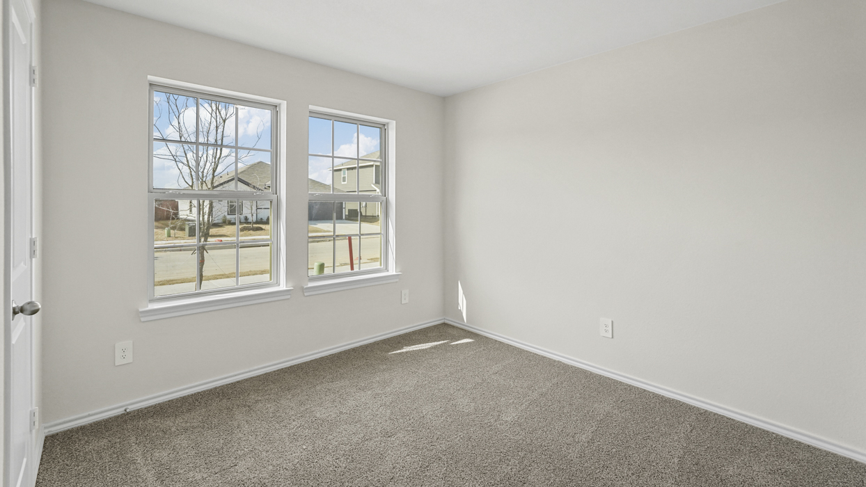 an empty bedroom with gray carpet and white walls