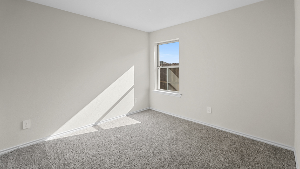 an empty bedroom with gray carpet and white walls