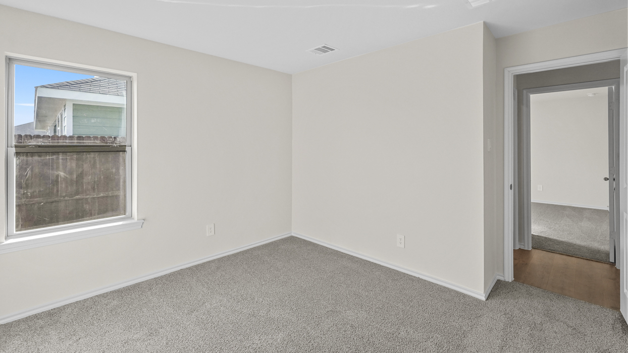 an empty bedroom with gray carpet and white walls