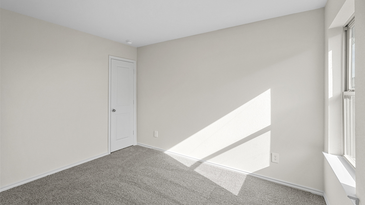 an empty bedroom with gray carpet and white walls