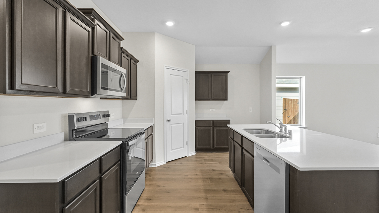 a kitchen with dark cabinets and an island in the middle with white counter tops