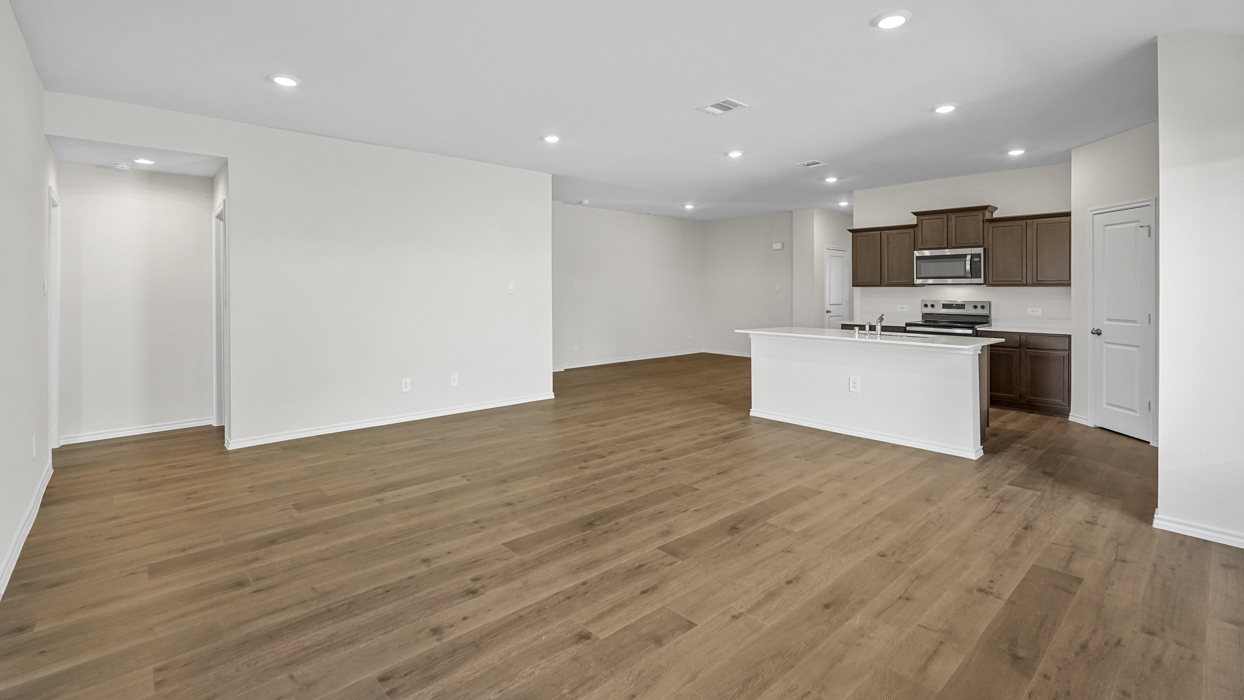 an open living area with wood floors and white walls