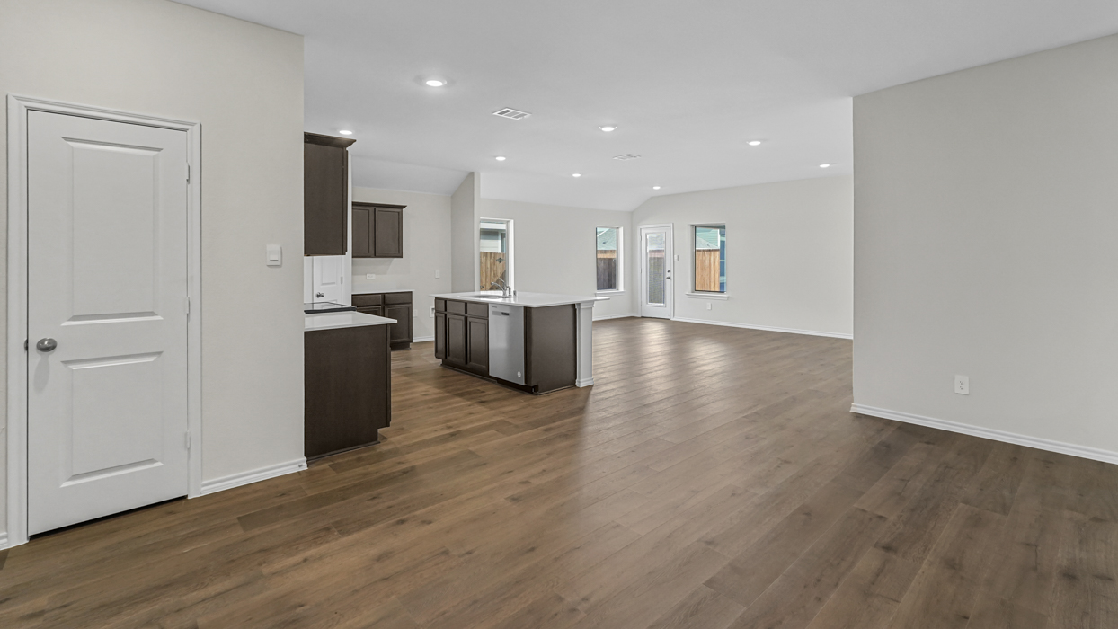 an open living area with wood floors and white walls
