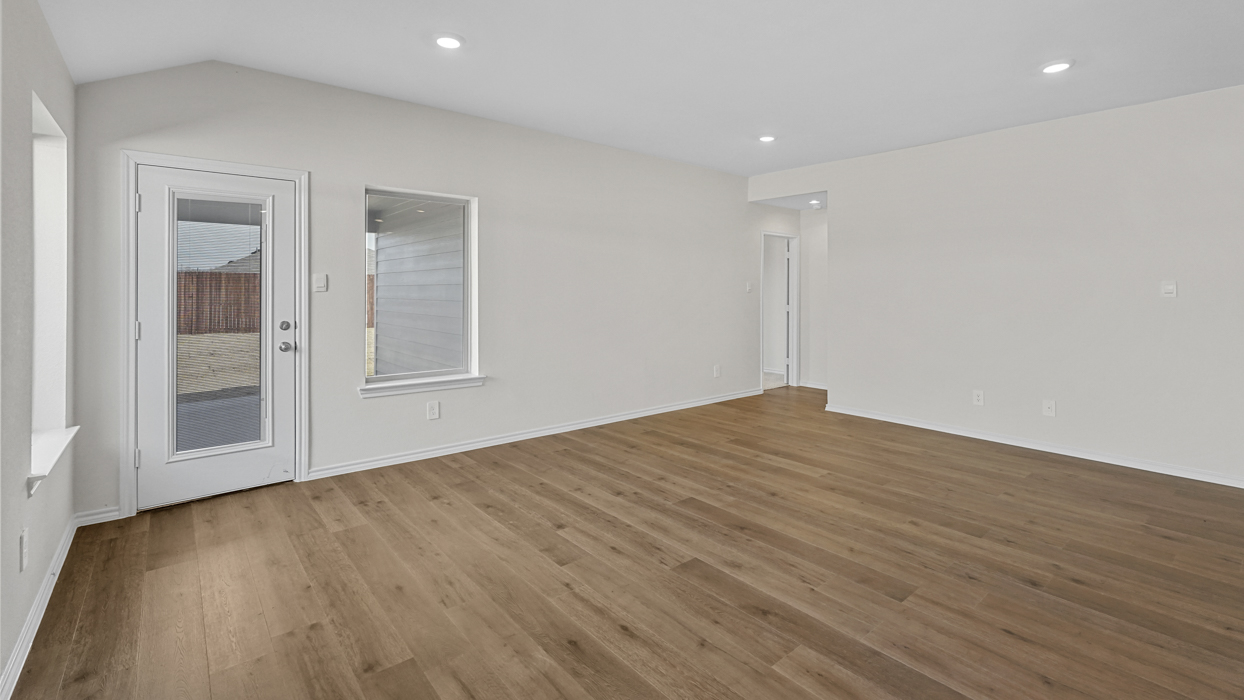 an open living area with wood floors and white walls