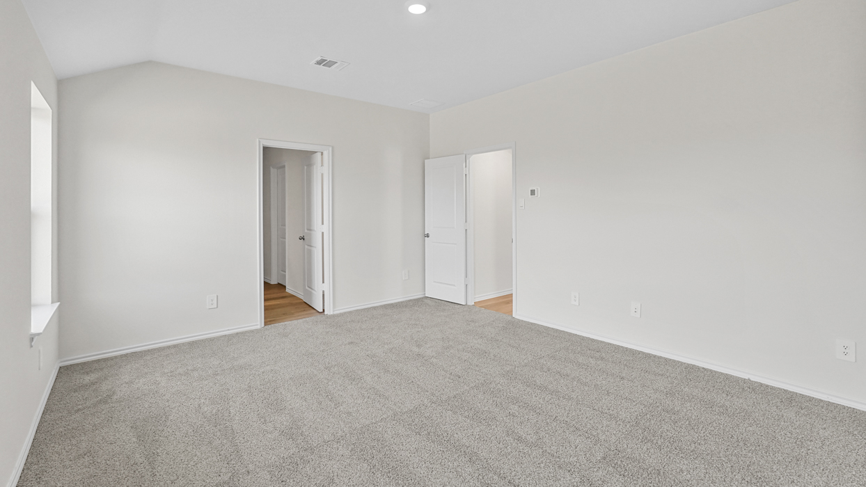 an empty bedroom with gray carpet and white walls