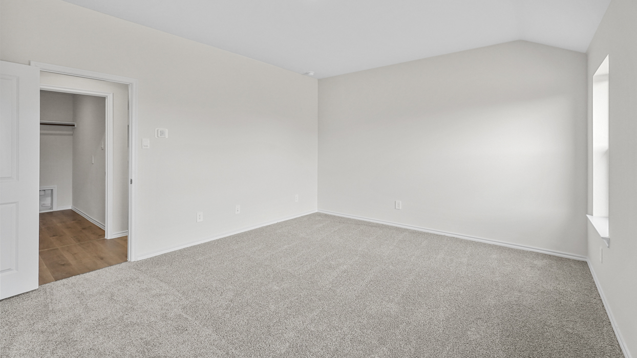 an empty bedroom with gray carpet and white walls