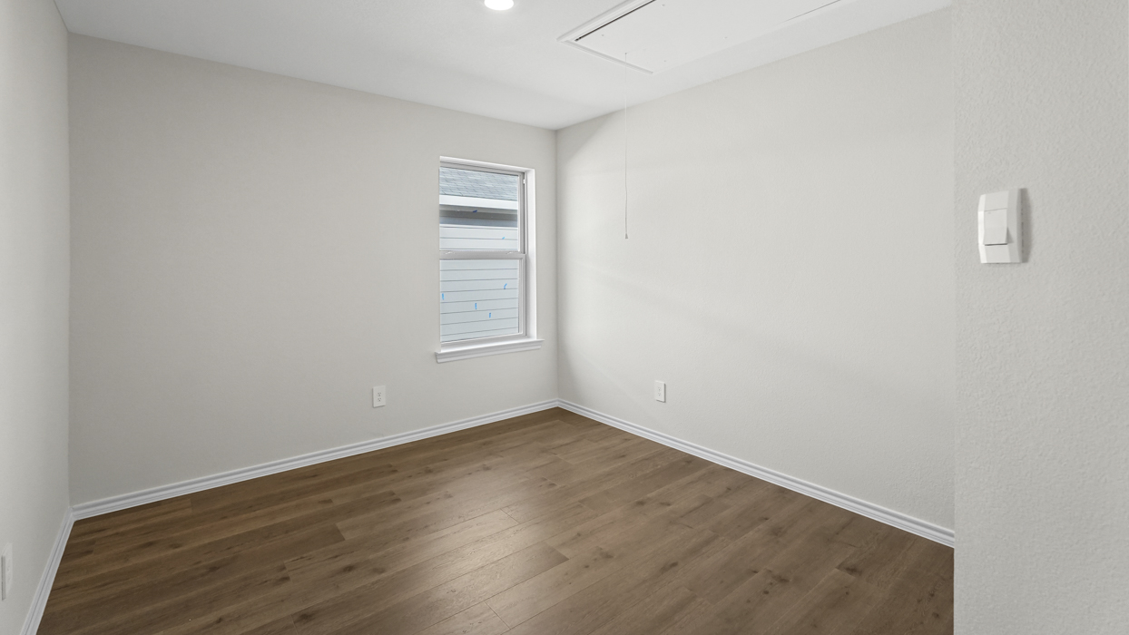 a study or flex room with wood floors and white walls