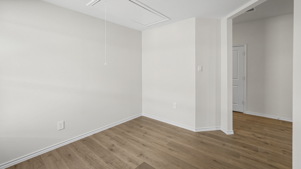 a study or flex room with wood floors and white walls