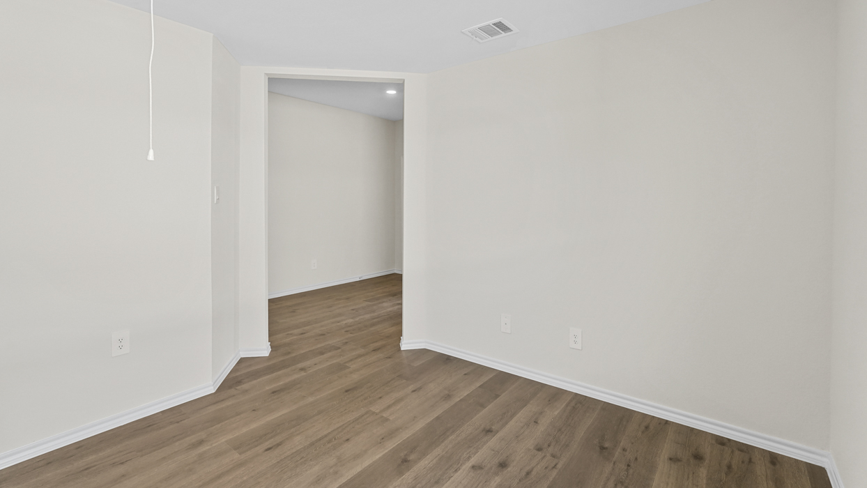 a study or flex room with wood floors and white walls