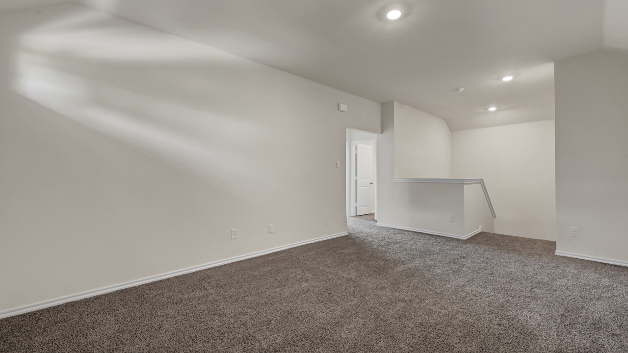 an empty bedroom with gray carpet white walls and windows