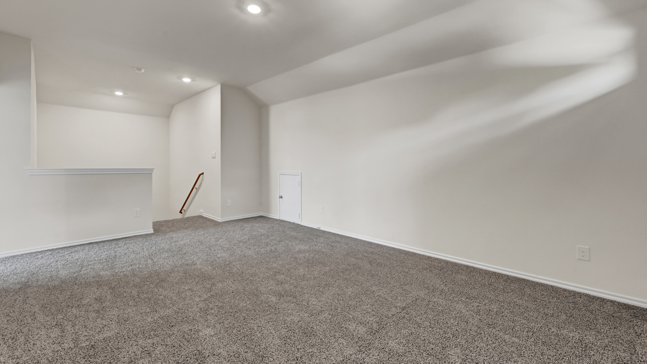 an empty bedroom with gray carpet white walls and windows