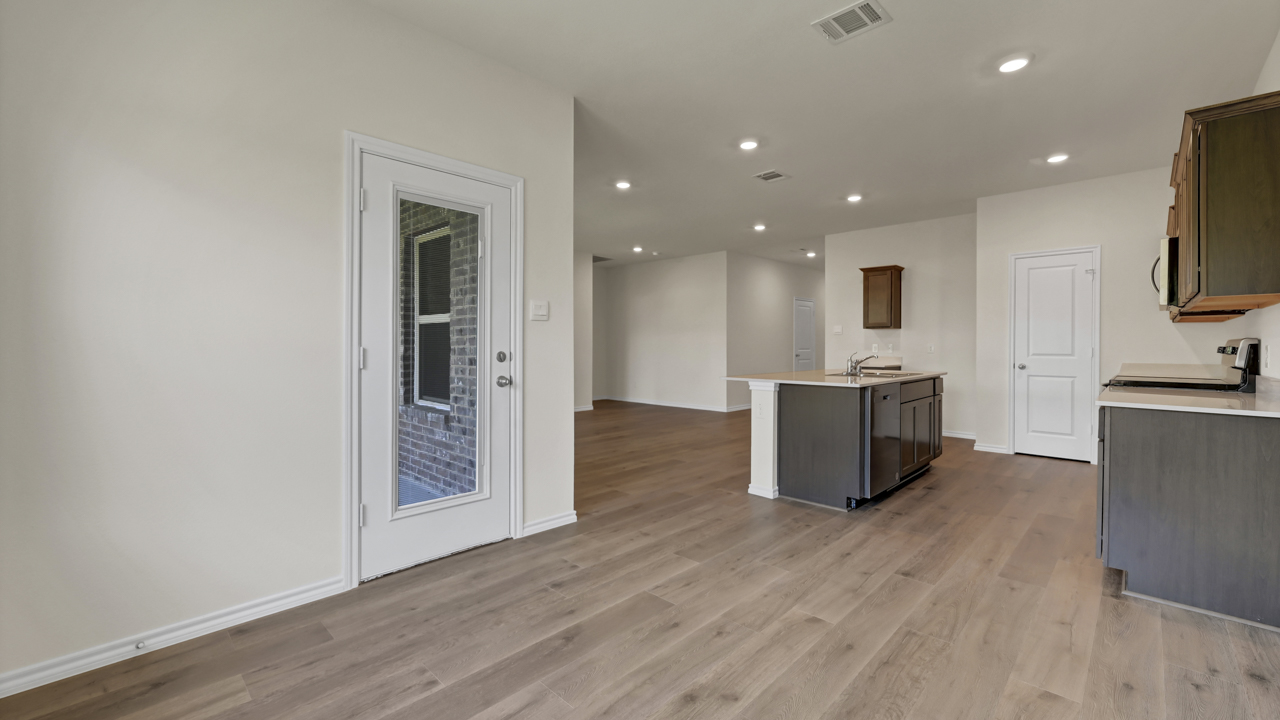 an open living area with wood floors white walls and windows