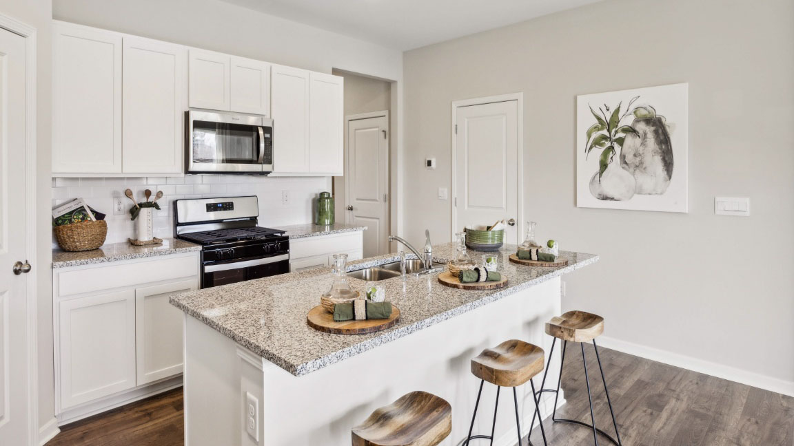 Large kitchen with white cabinets and center island