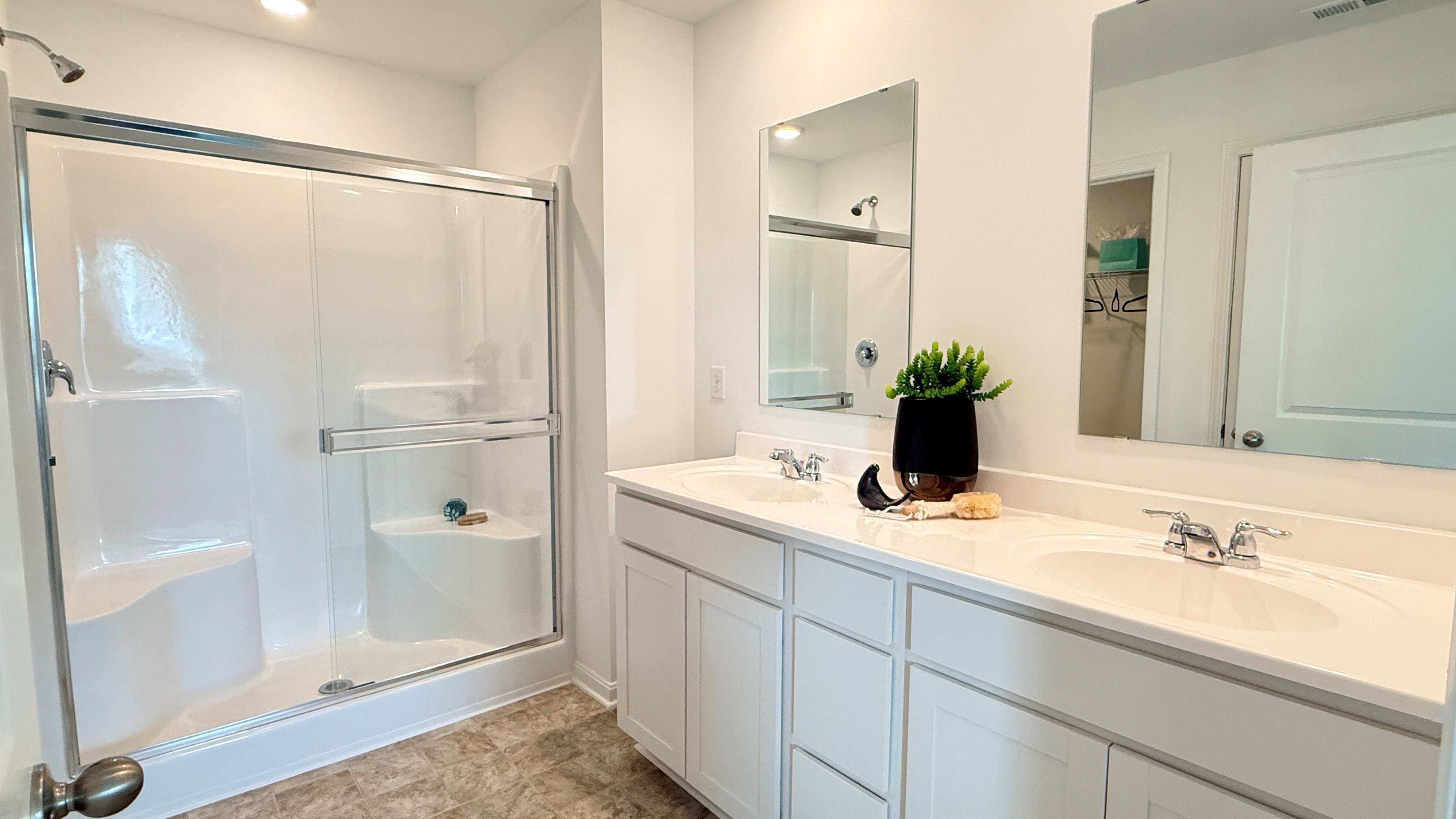 Upstairs primary bathroom with double bowl vanity and walk-in shower.