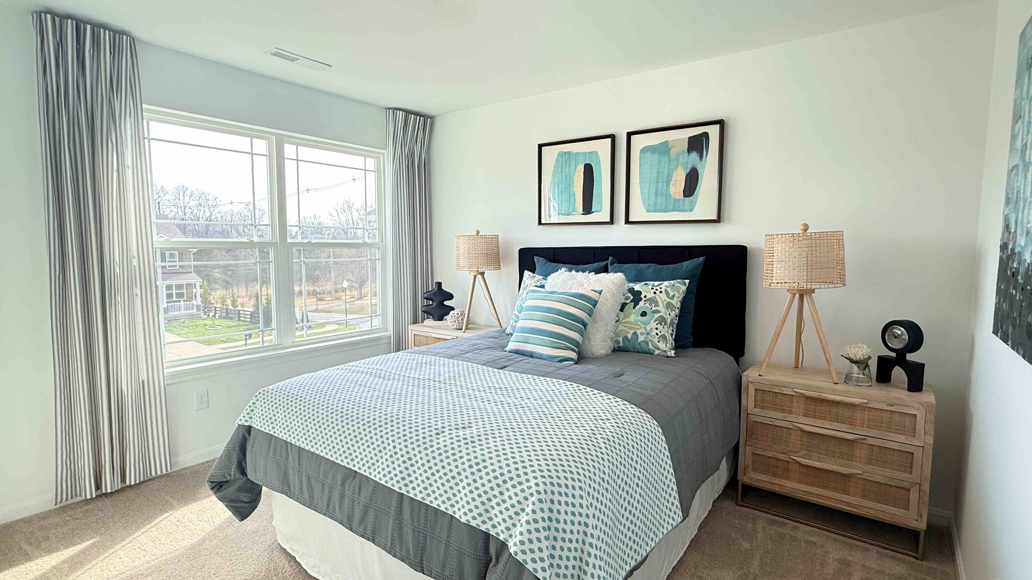 Upstairs spare bedroom with bed, 2 nightstands, and double window overlooking the front yard.