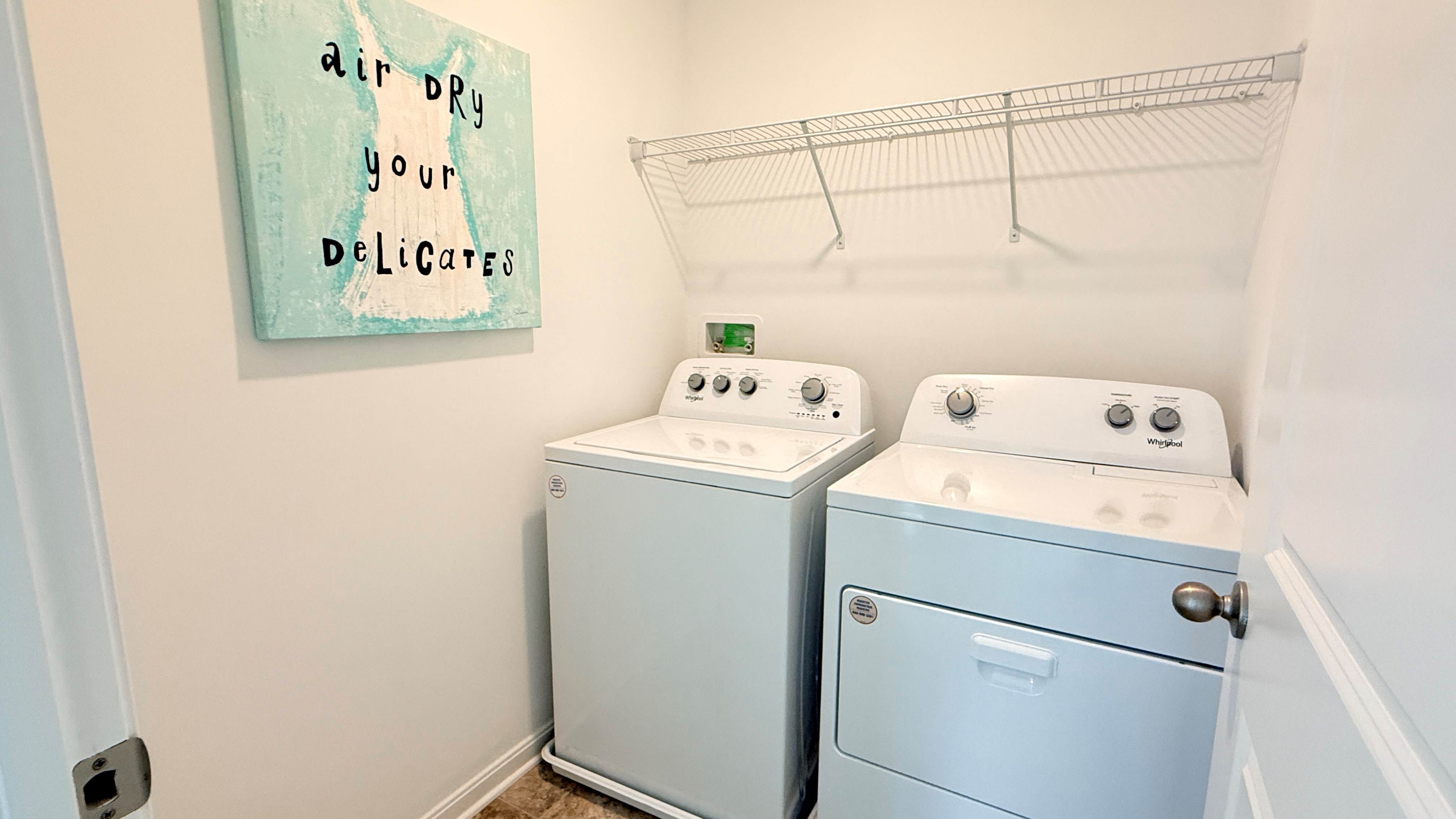 Upstairs laundry room with wire shelf above the washer and dryer.