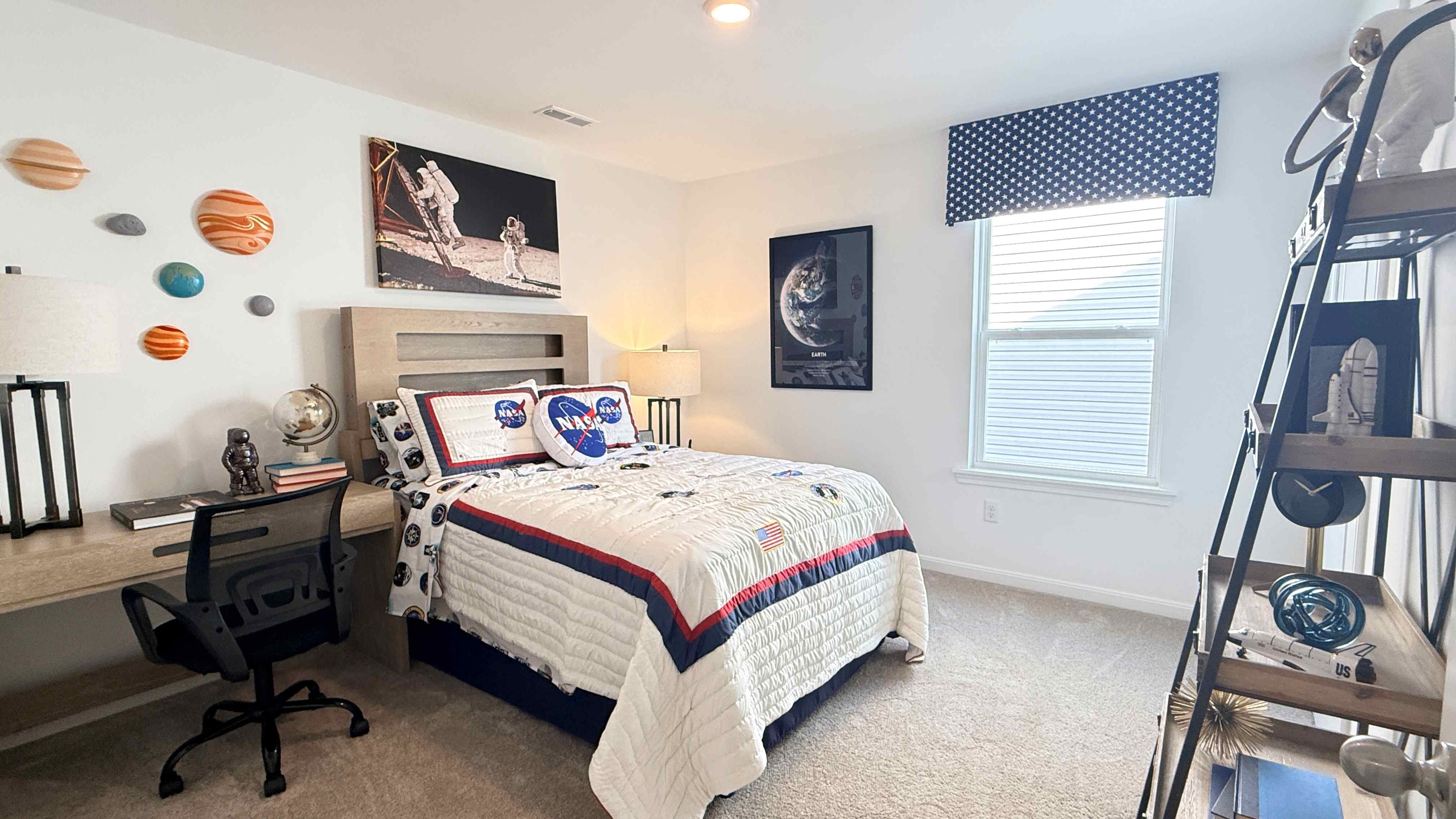 Upstairs spare bedroom with NASA theme. Bed, desk, nightstand, bookcase, and single window.