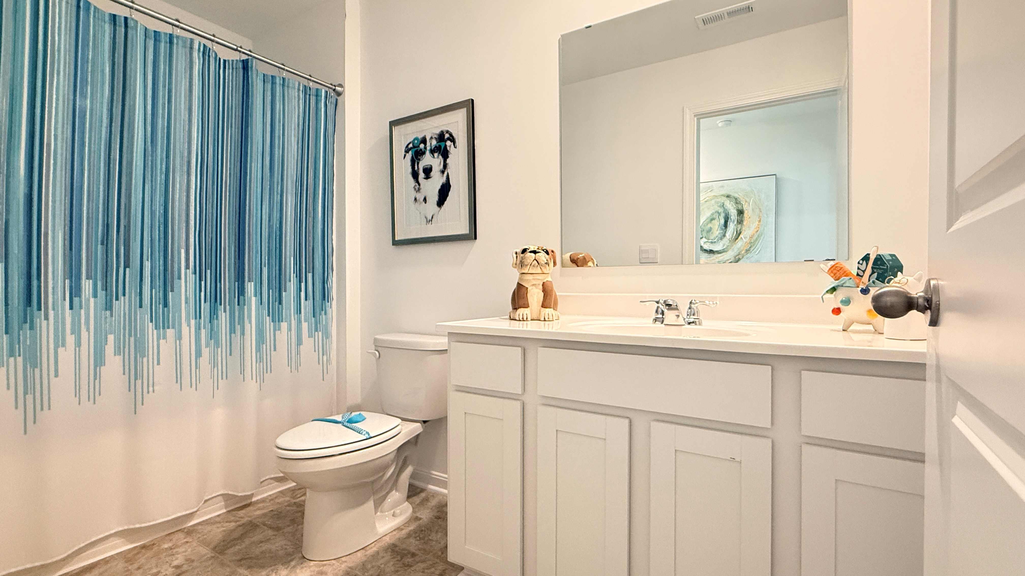Upstairs hall bathroom with vanity, commode, and shower/tub combo.