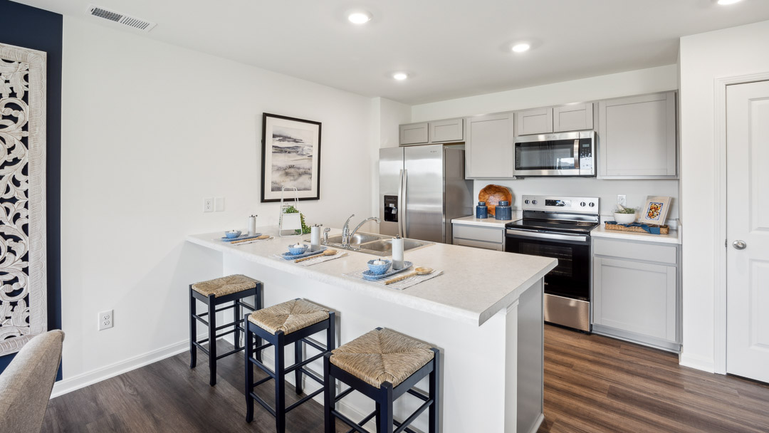 galley style kitchen with stainless steel appliances and seating at pennisula